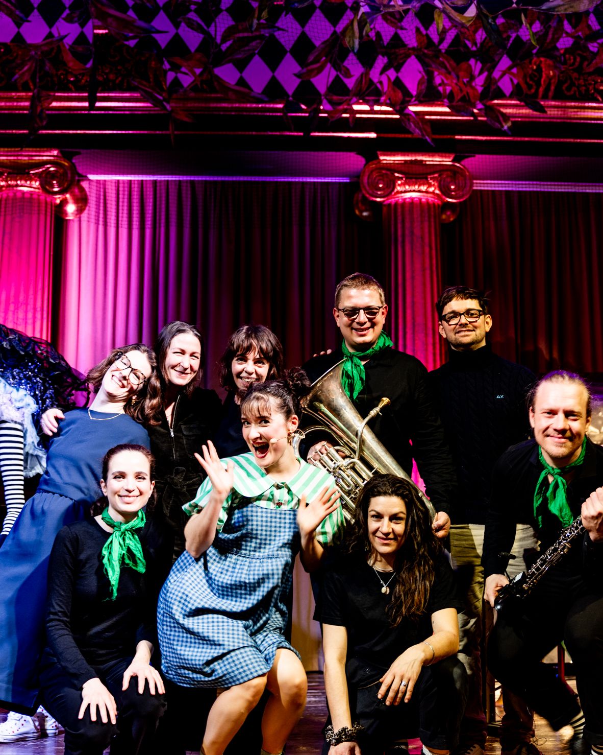 The ensemble with green neckerchiefs poses cheerfully for a group photo.
