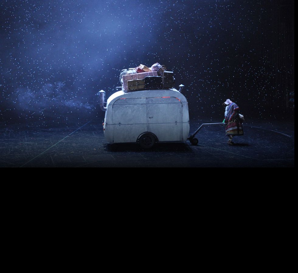 A small caravan loaded with luggage under a starry night sky.