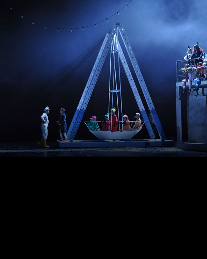 Children on a swinging boat, lit in cold blue light.