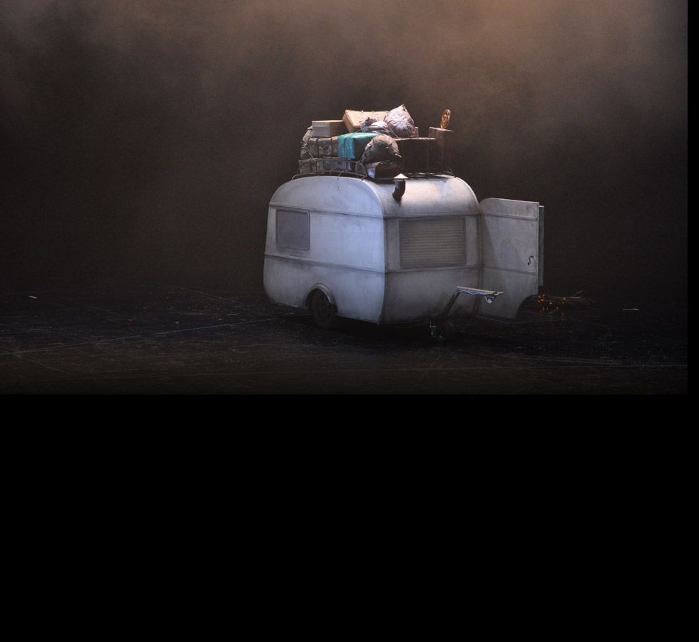 The caravan alone on the empty, fog-covered stage.