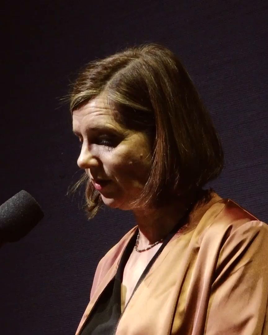 A woman speaks into a microphone.
