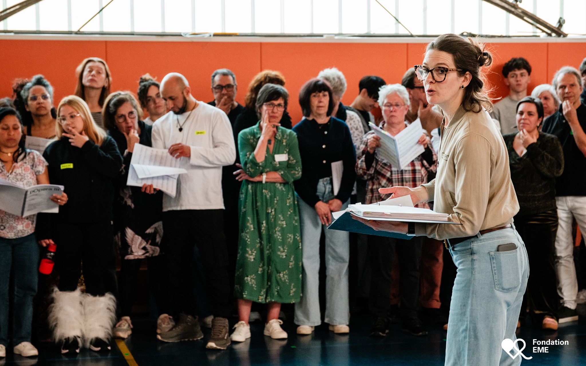Anisha Bondy rehearses with a large choir of participants of all ages.