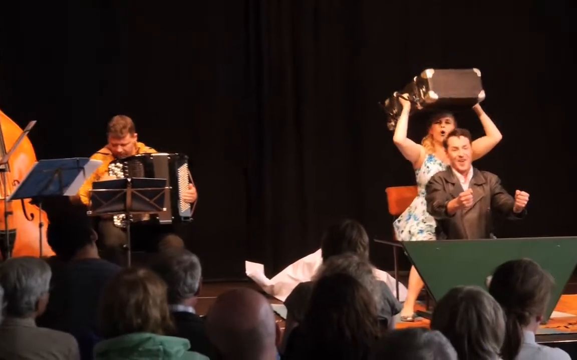 Double bass and accordion beside the two singers, the audience in front of the stage.