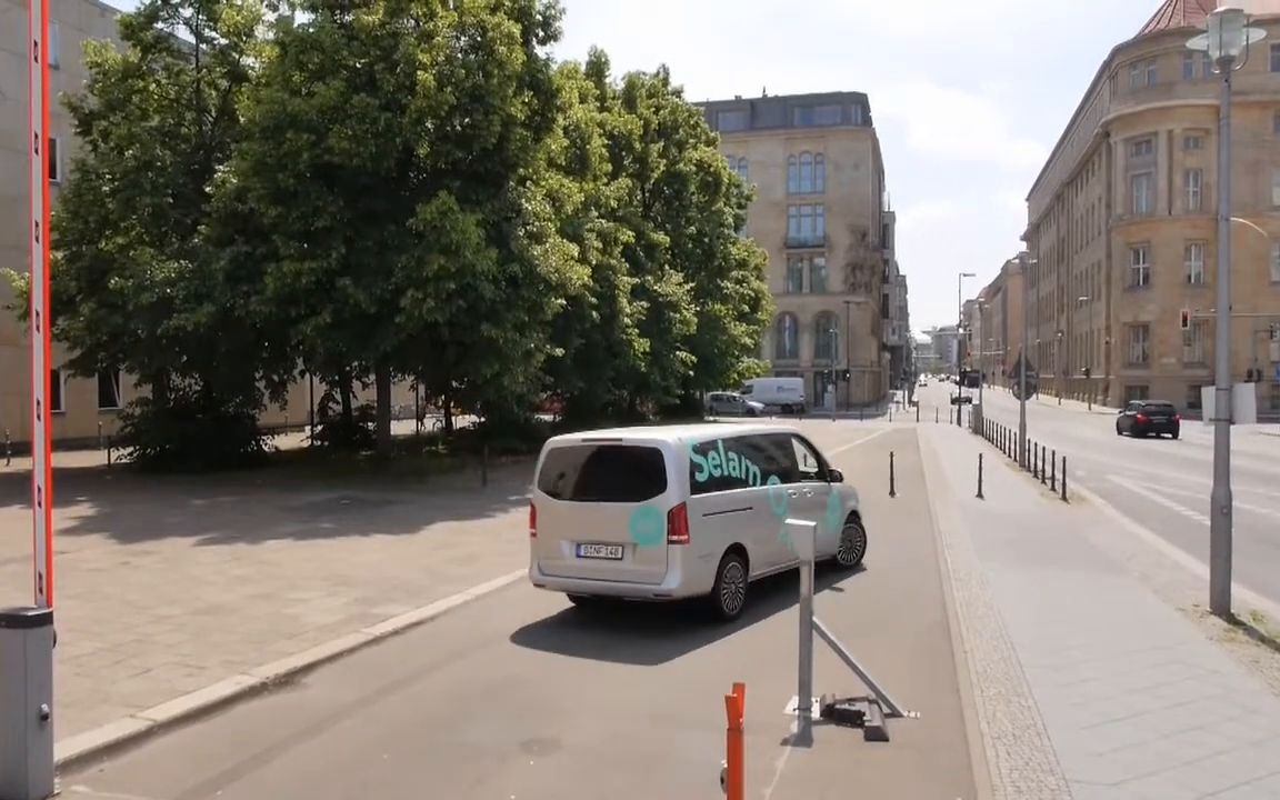 The bus drives off down a wide street between old buildings.